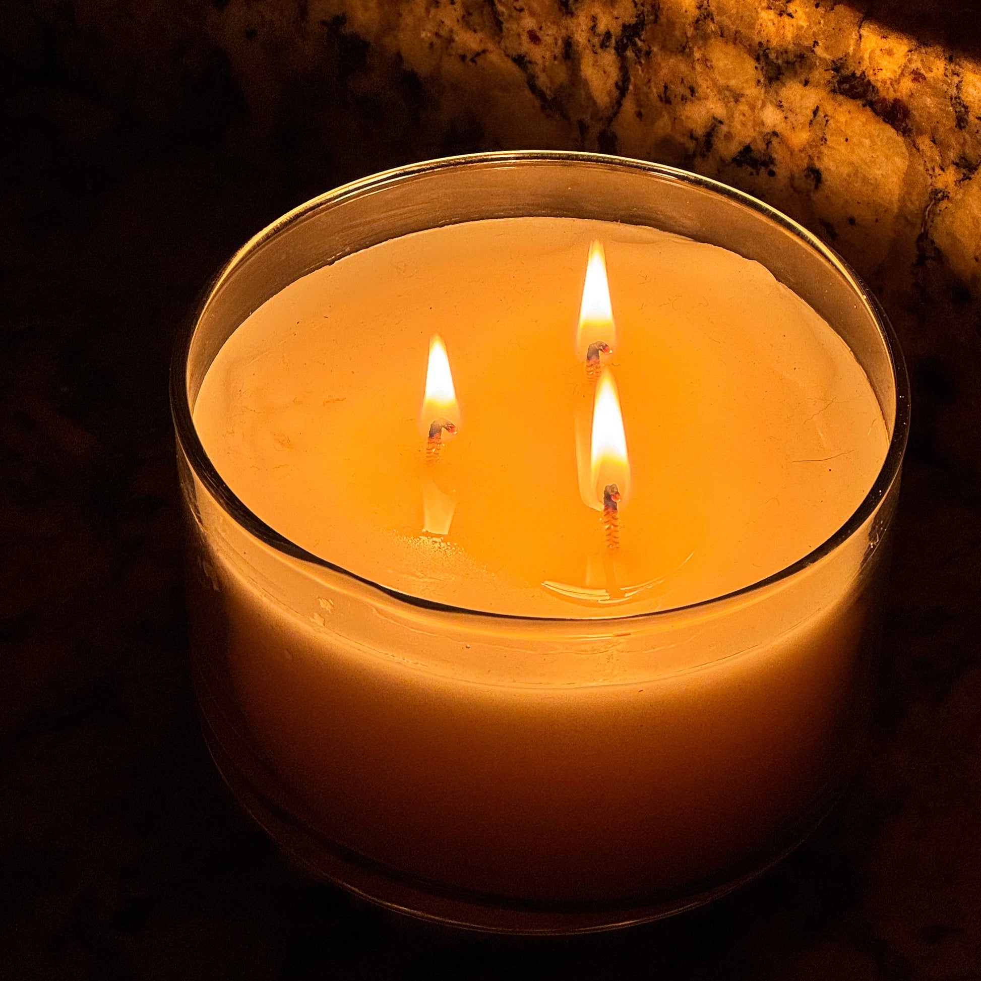 Candle in a metal holder with a warm glow on a dark background